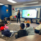 Amy Danos, Director of Special Events and Grant Management, with students in classroom.