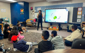 Amy Danos, Director of Special Events and Grant Management, with students in classroom.