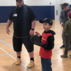 Student and coach working on baseball skills.
