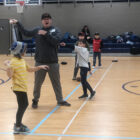 Students and coach working on baseball skills.