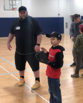 Student and coach working on baseball skills.