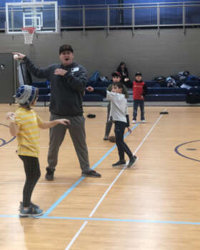Students and coach working on baseball skills.